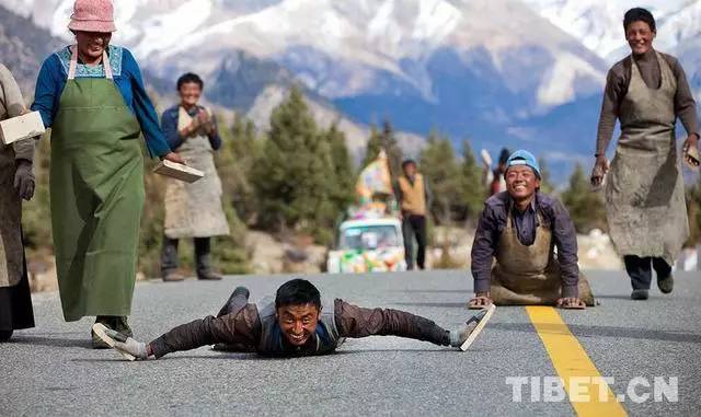 他们拉着板车带着食物三步一拜去朝圣